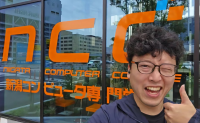 男性,眼鏡,笑顔,親指を立てる,店舗前,コンピューターショップ,看板,日本語,英語