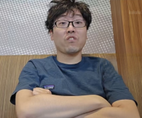 男性,メガネ,短髪,青いTシャツ,腕組み,室内